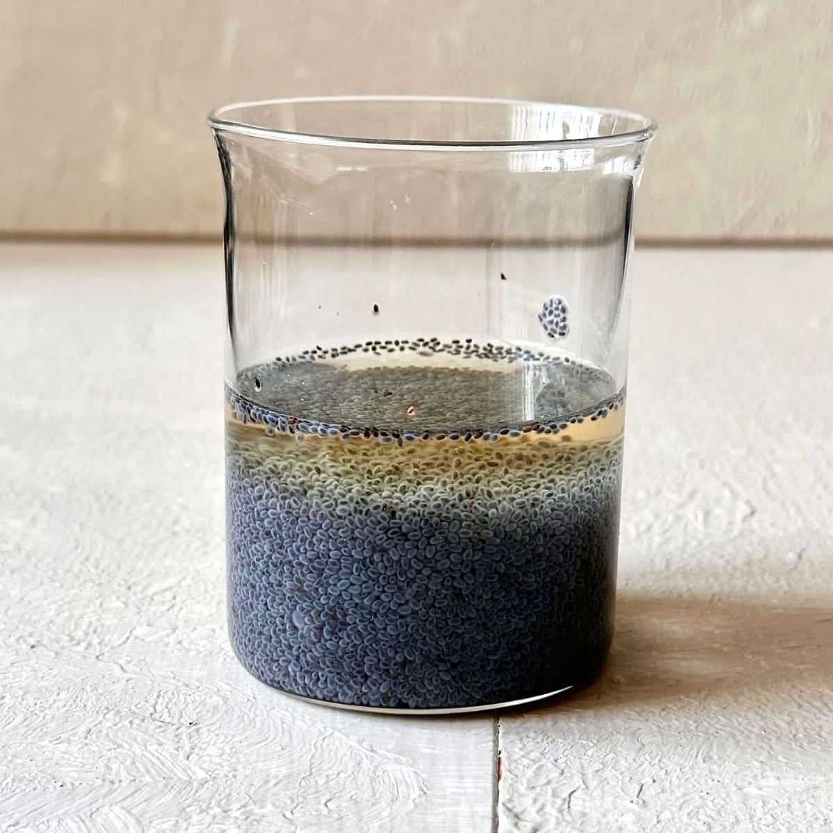 Basil seeds soaked in water until swollen in a glass beaker.