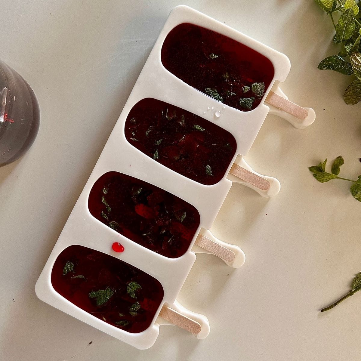 Rose and basil seed mixture poured into popsicle silicone moulds.