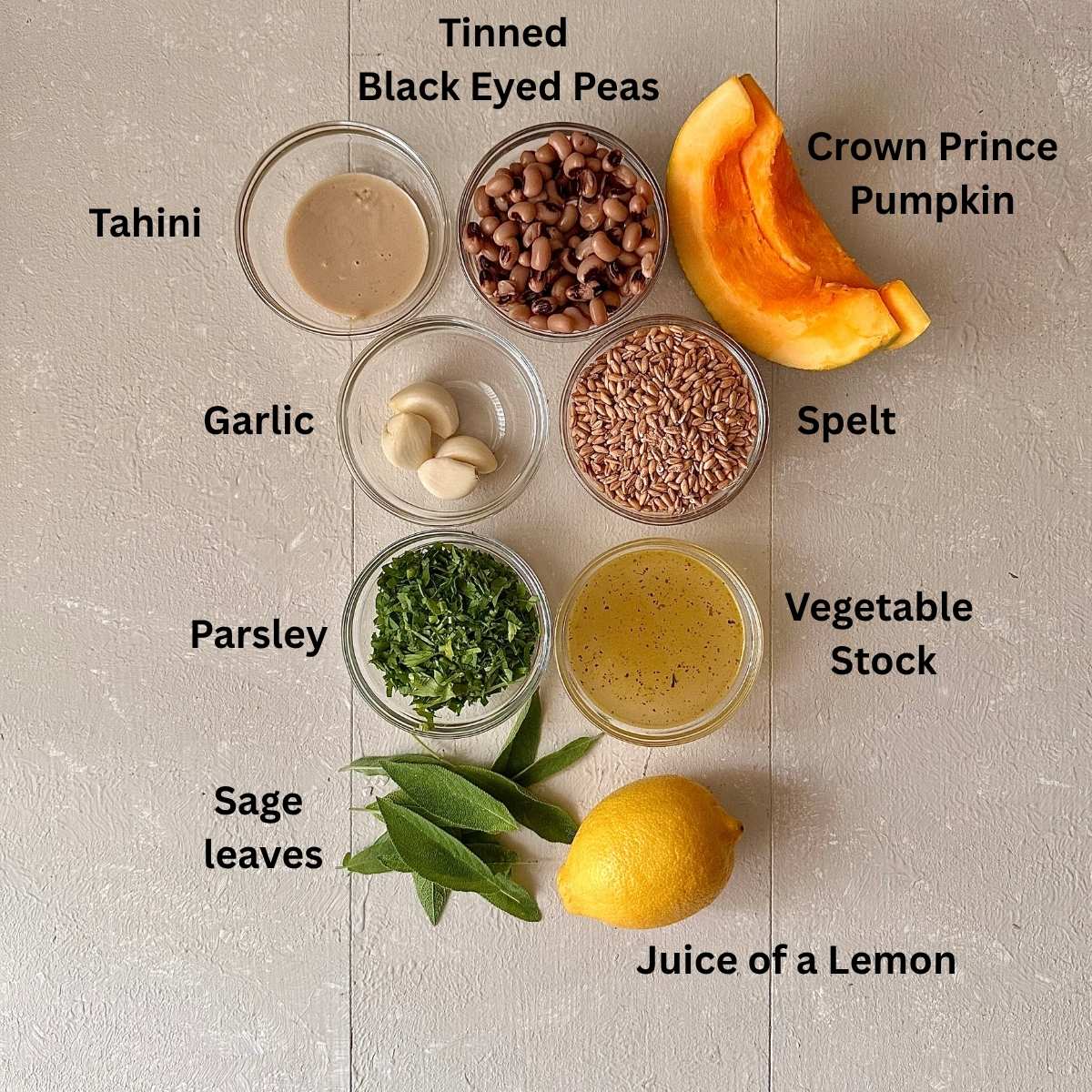Ingredients for roasted pumpkin black eyed pea hummus in small glass dishes. The ingredients are annotated.