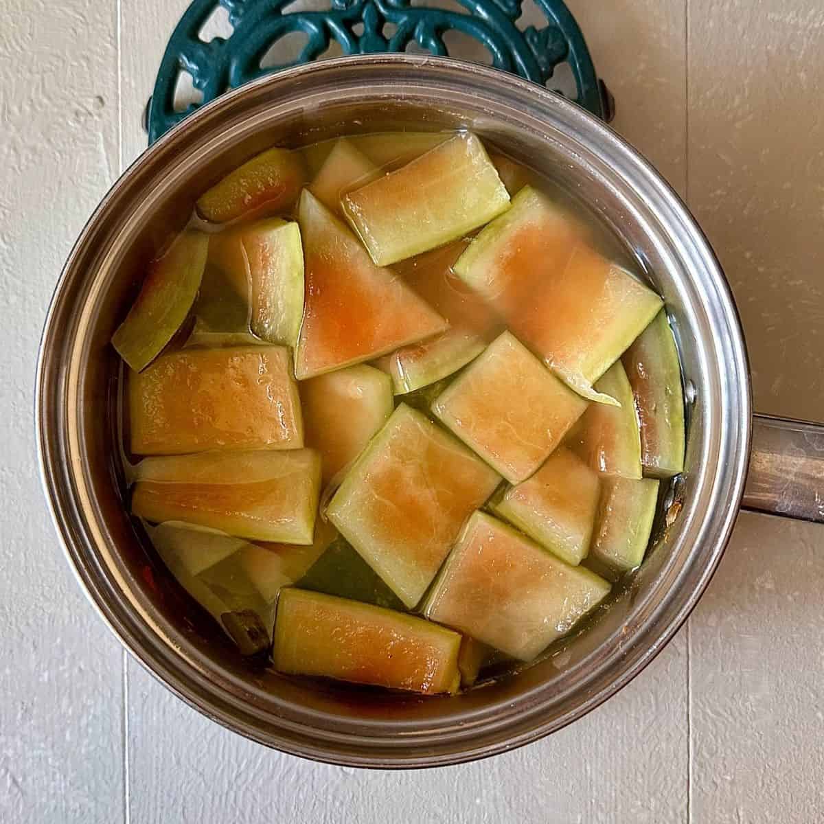 A steel saucepan containing watermelon rind in water ready to be blanched. For watermelon rind hummus recipe.