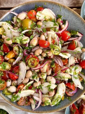 A plate if borlotti bean salad with heirloom tomatoes, chilli and cucumber.
