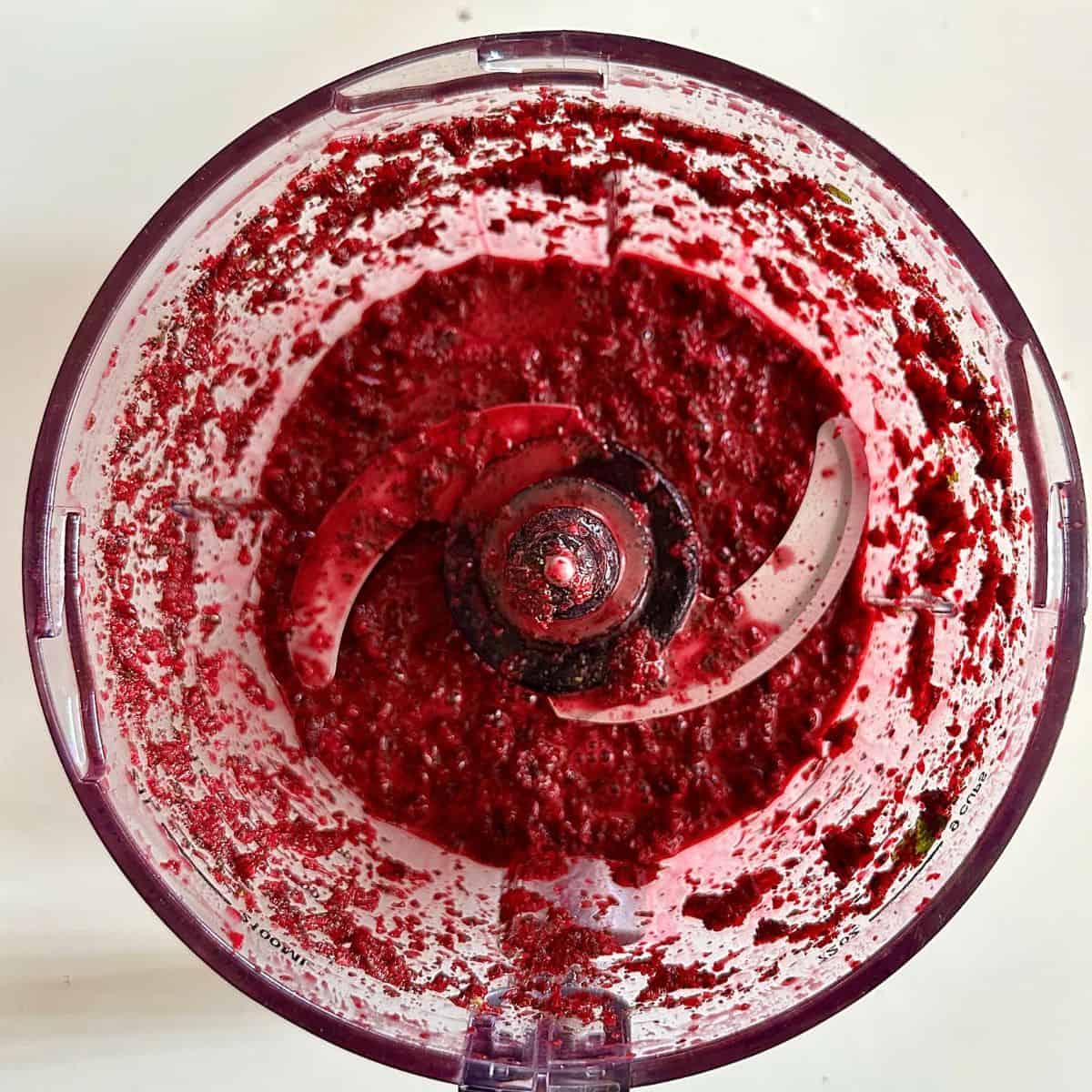 A jug blender containing roughly blended ingredients for beetroot aguachile.