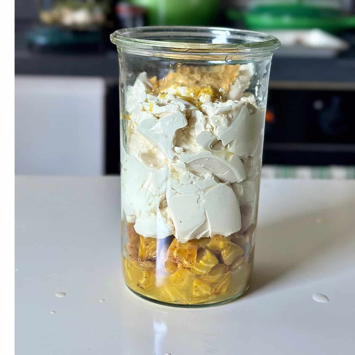 Roasted golden beetroot dice, soft tofu, nutritional yeast, olive oil, lemon juice and zest in a tall glass jar ready to blend together with a stick blender. For a beetroot dip recipe.