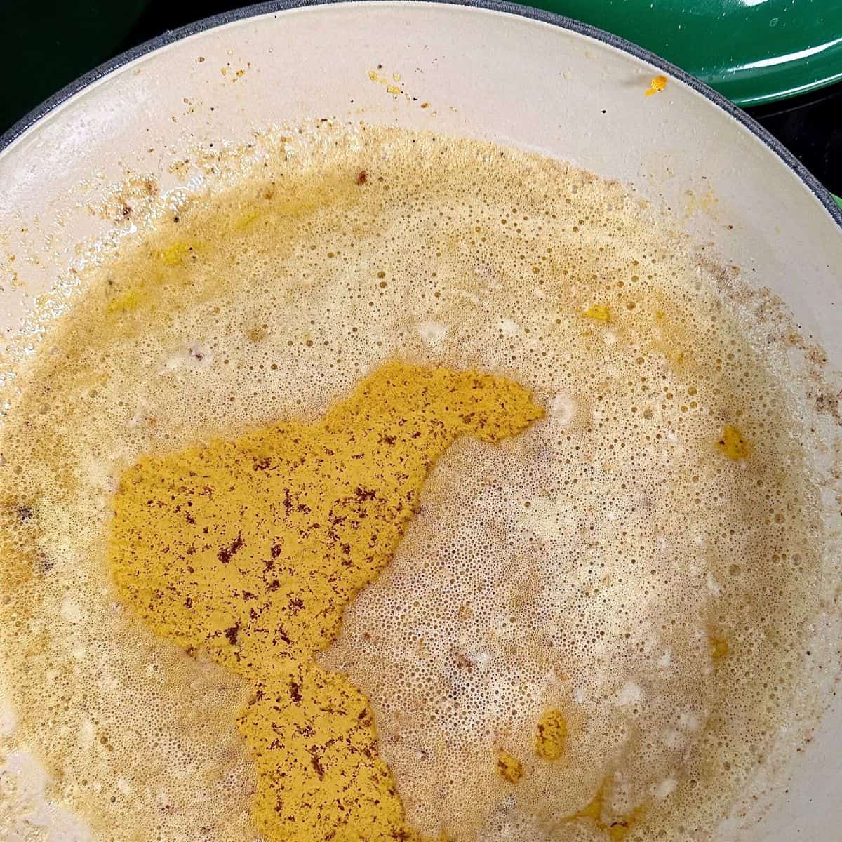 Close up of brown butter in a large pan. For a pumpkin orzo recipe.