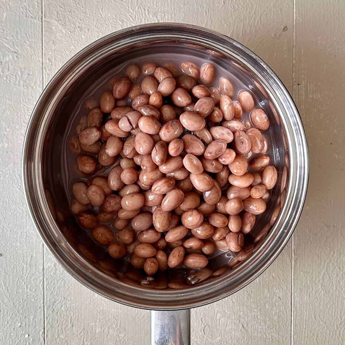 A steel saucepan containing cooked borlotti beans for a beetroot skewers with a borlotti bean dip recipe.