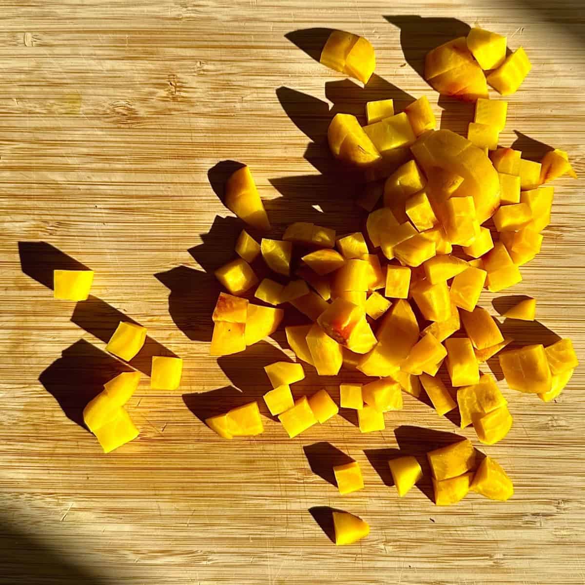 Golden beetroot chopped into 10mm dice on a wooden chopping board. For a beetroot thoran recipe.