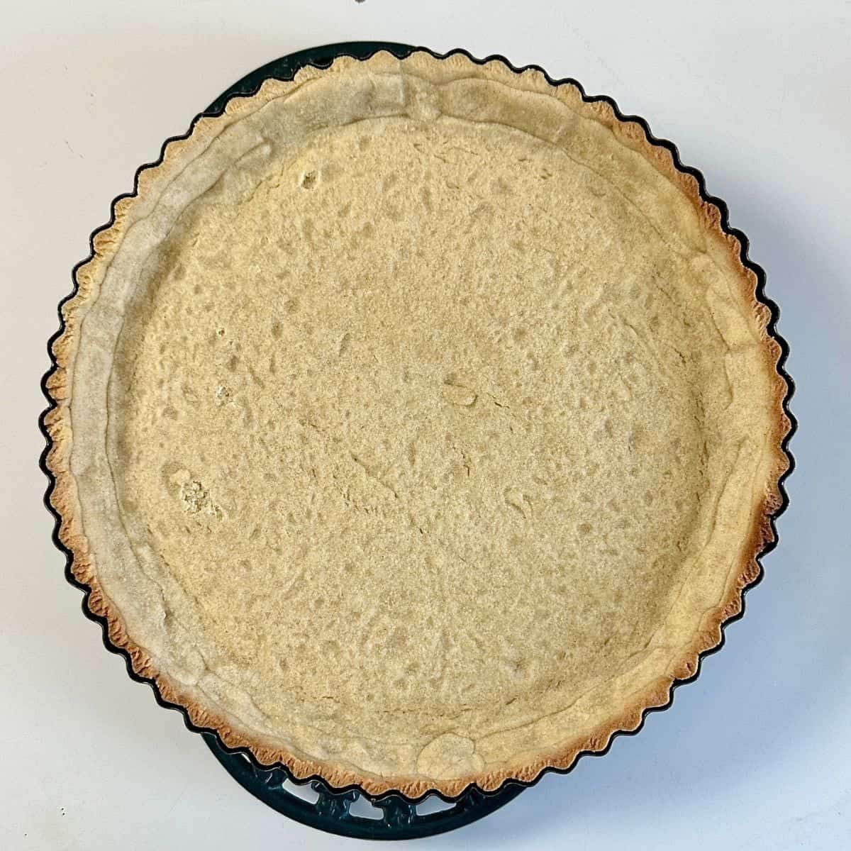 A baked pastry base for a vegan quince frangipane tart recipe.